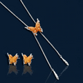 Amber wood butterfly pendant necklace with dangling chains and matching carved wood butterfly earrings on white background.